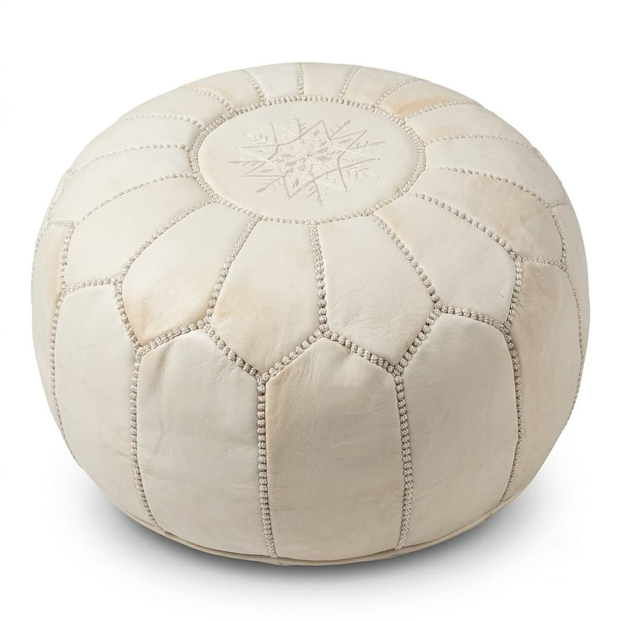 Undyed natural cream Moroccan leather round pouf on a plain white background