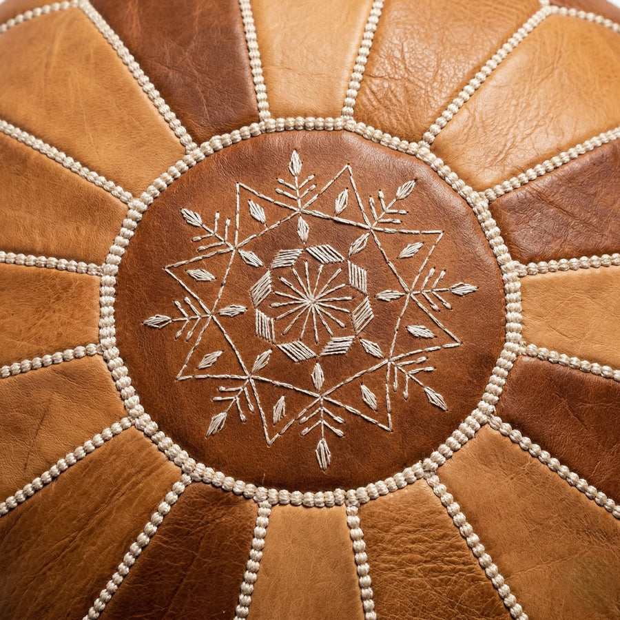 Close-up of the hand-embroidered eight-pointed star and cream whipstitch seams on the pouf top panel