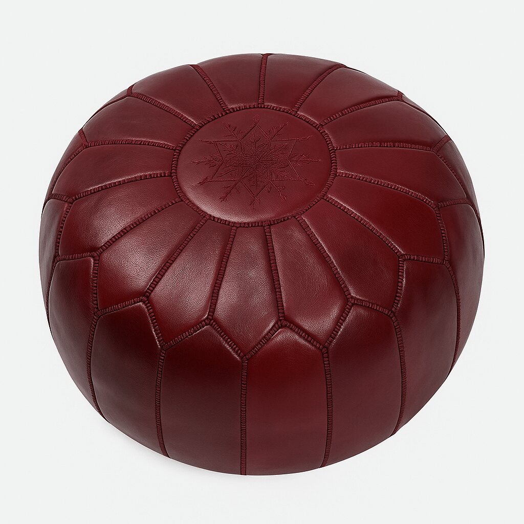 Deep red Moroccan leather round pouf with hand-embroidered star medallion on a plain background
