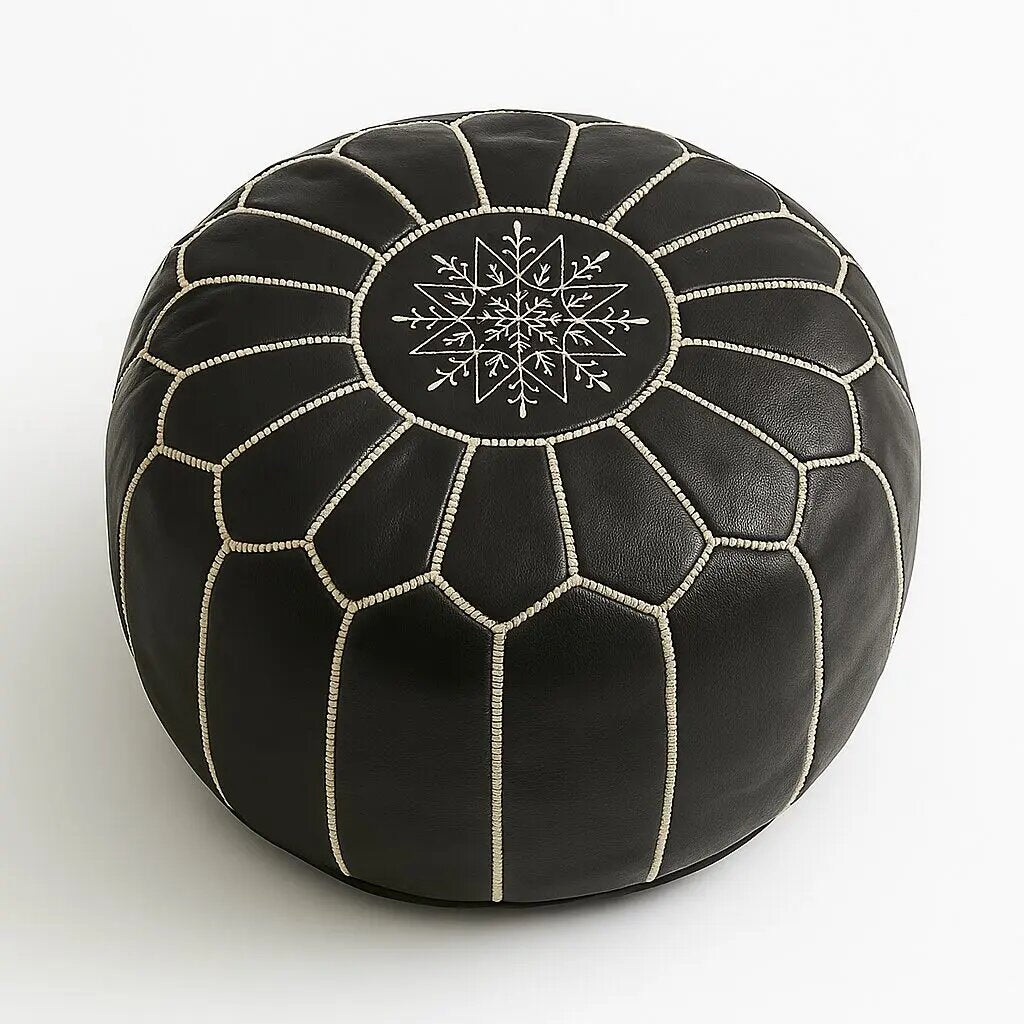 Overhead view of a black Moroccan leather pouf with white contrast stitching