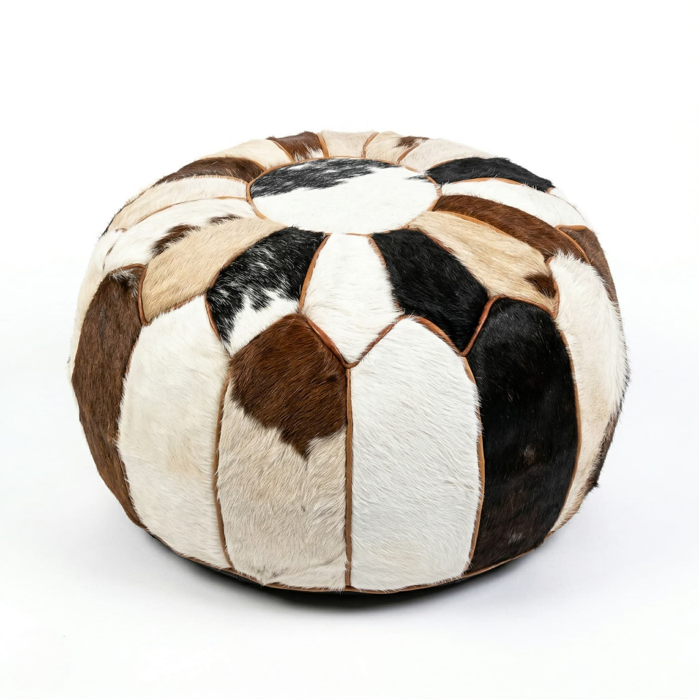 Moroccan cowhide round pouf, 21 inch hair-on-hide patchwork ottoman in brown, black and white, on a white background