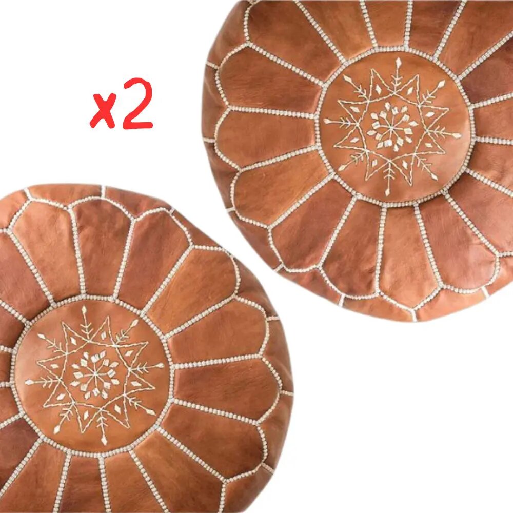 Set of two tan Moroccan leather round poufs with cream star embroidery, on a plain white background