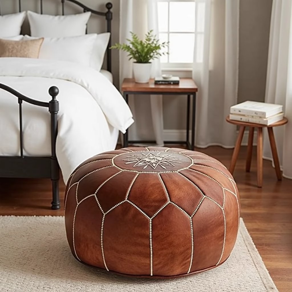 Tan leather pouf beside a potted plant in a bright minimalist corner