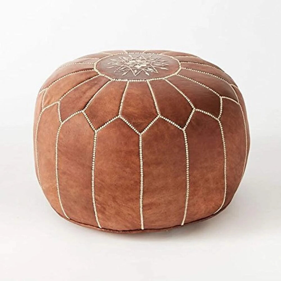 Single tan Moroccan leather pouf showing the hand-stitched panel seams