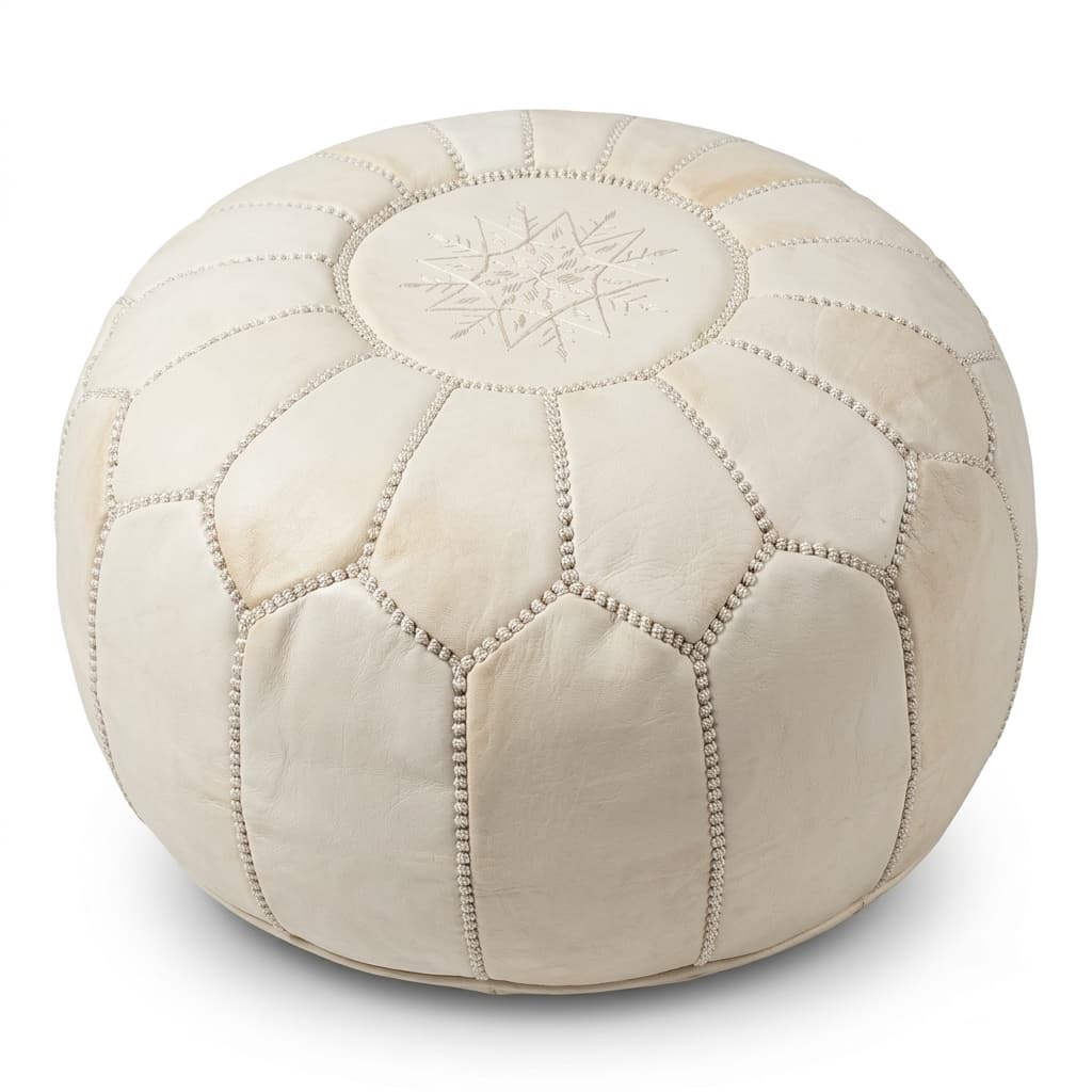 Undyed natural cream Moroccan leather round pouf on a plain white background