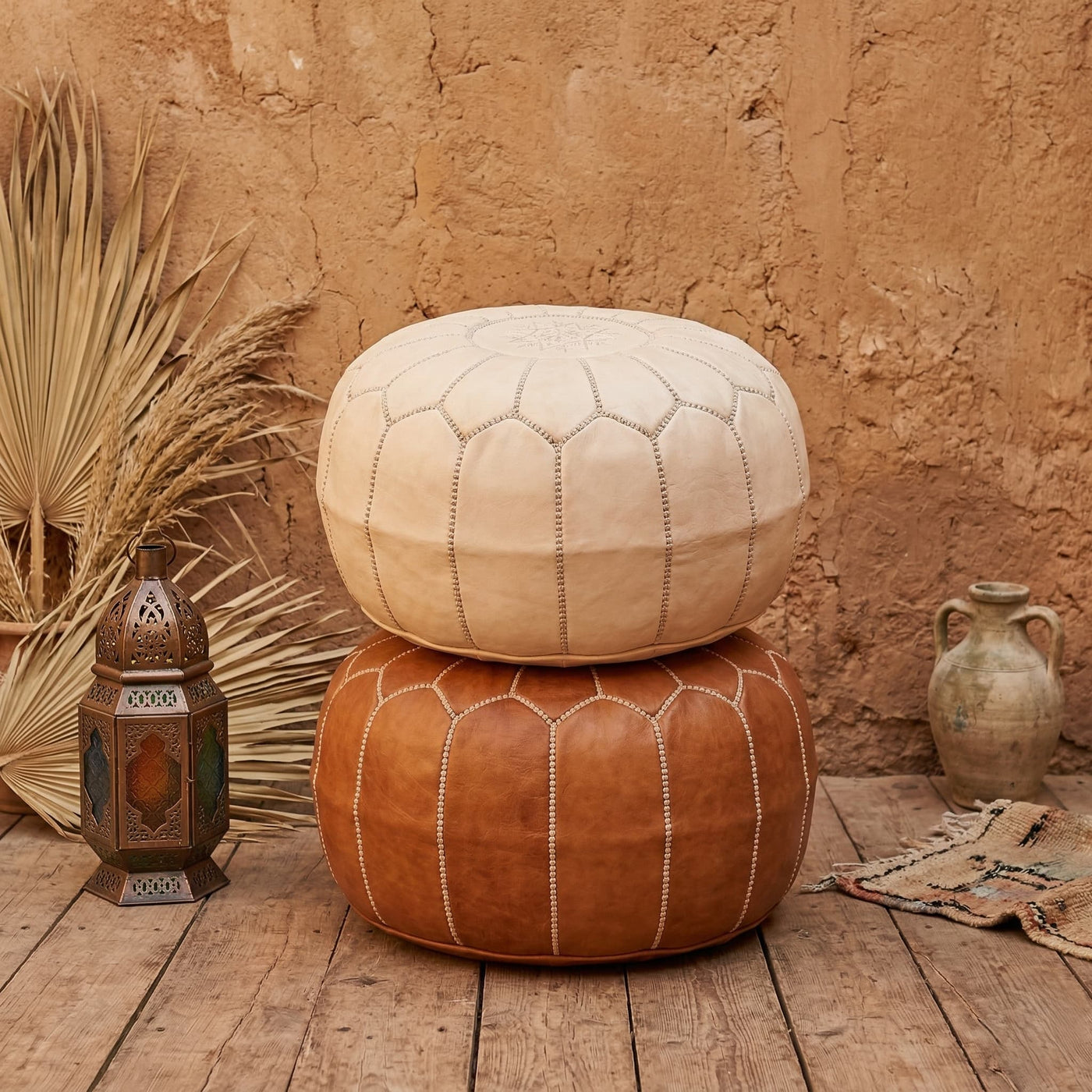Undyed leather pouf used as a footrest in a neutral interior