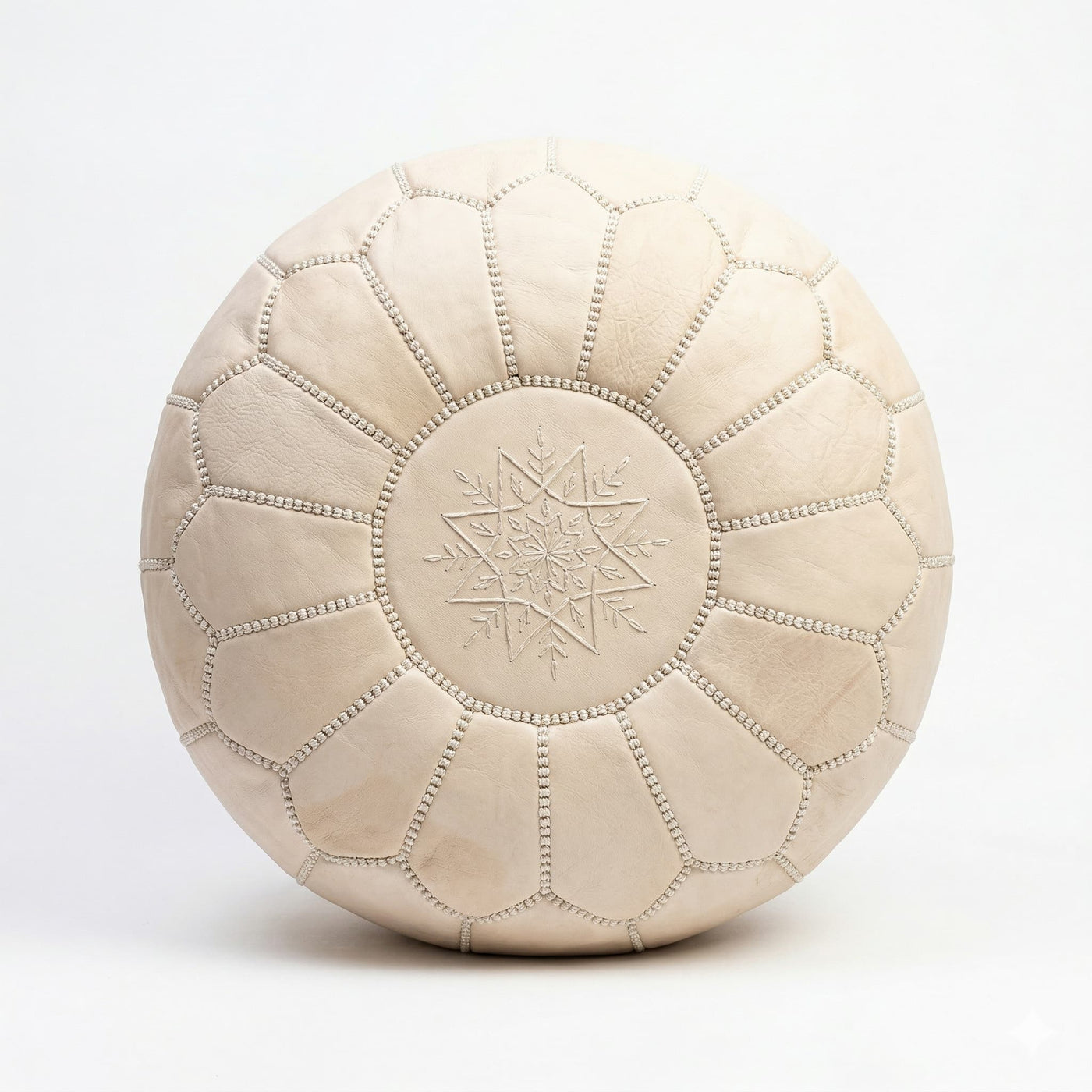 Top view of the undyed leather pouf showing the tonal star medallion embroidery
