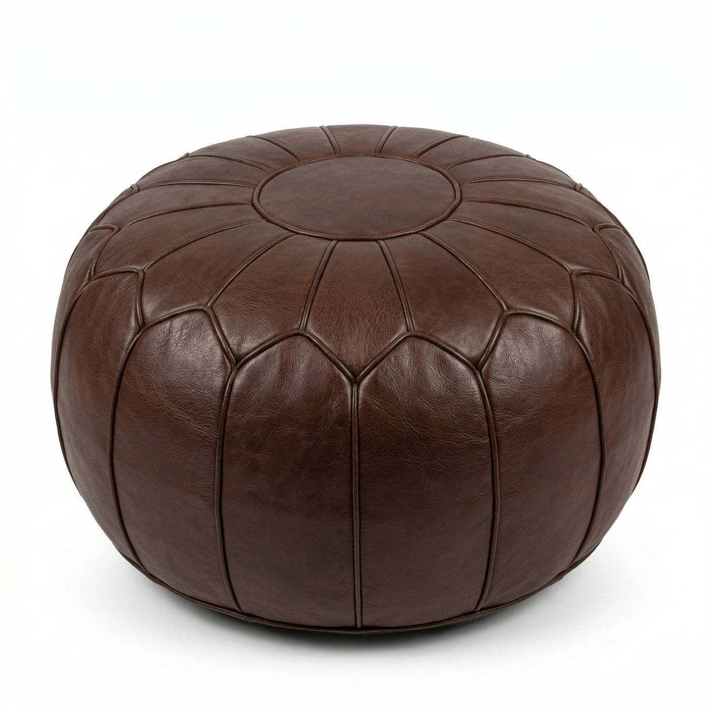 Chocolate brown leather pouf beside a cream sofa with a knitted throw