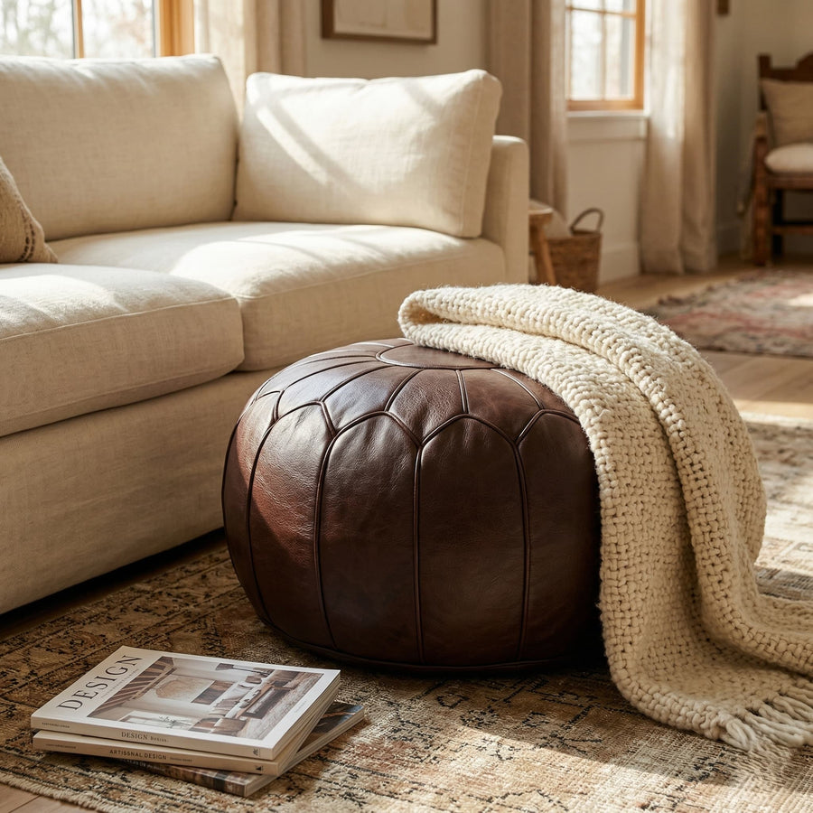 Dark brown leather pouf in a nursery beside a wooden rocking chair