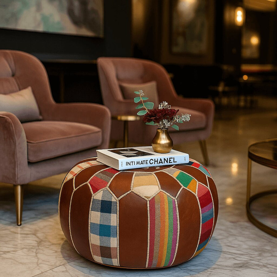 Patchwork leather pouf used as a boho coffee table between velvet chairs in a luxurious interior