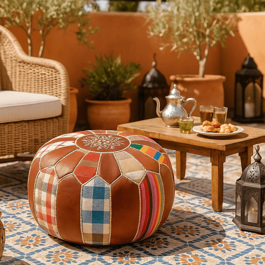 Patchwork pouf on an outdoor Moroccan terrace with a silver teapot and traditional mint tea glasses
