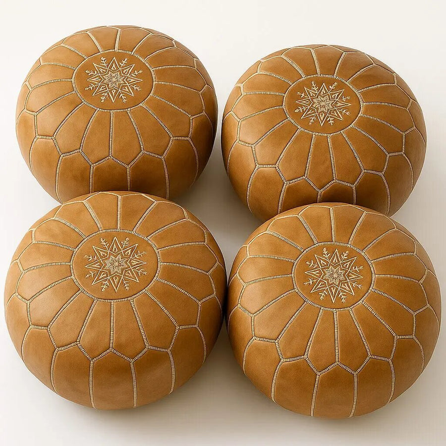 Four matching camel tan Moroccan leather poufs showing hand-stitched panels and star medallions