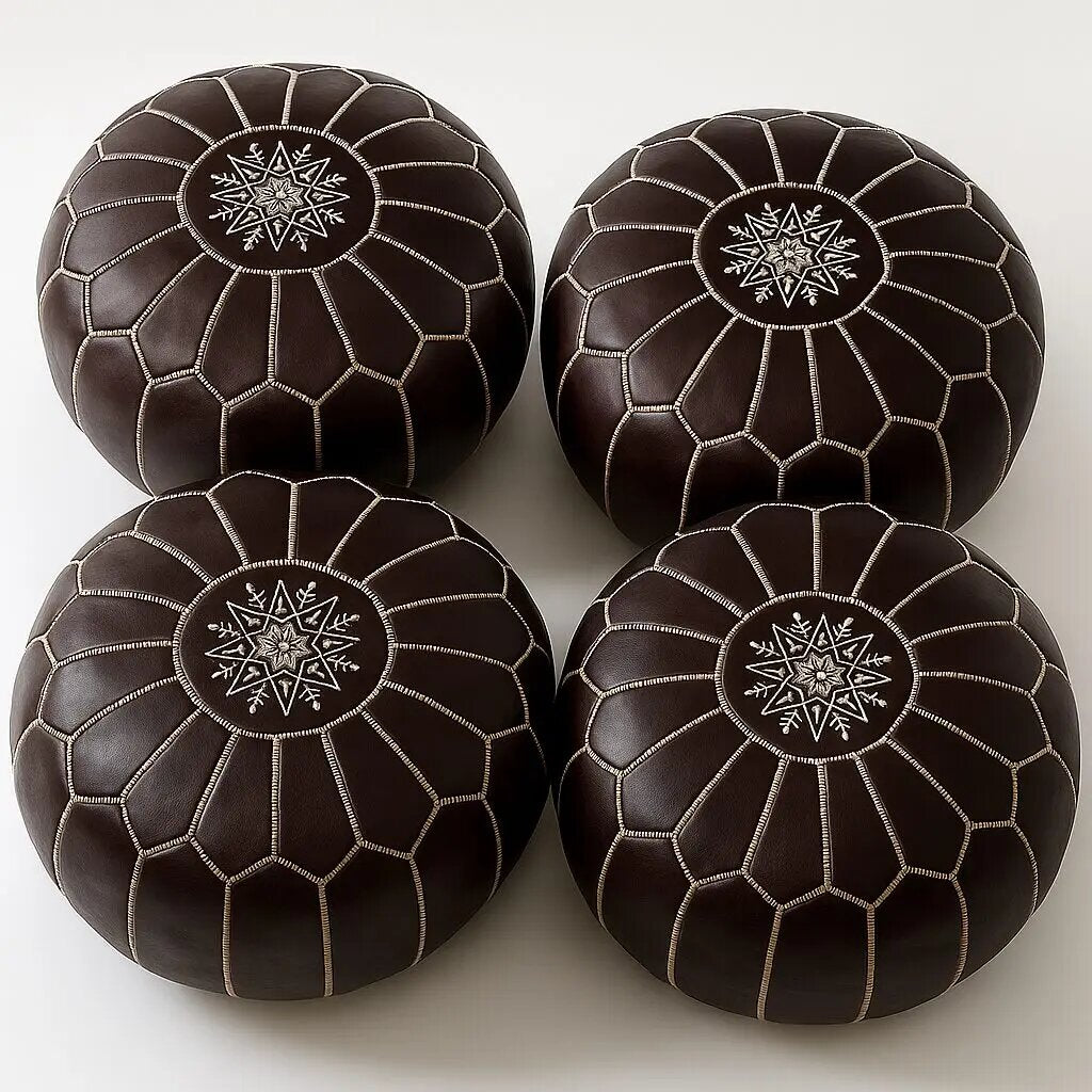 Four matching dark chocolate brown Moroccan leather poufs with off-white embroidery, viewed from above