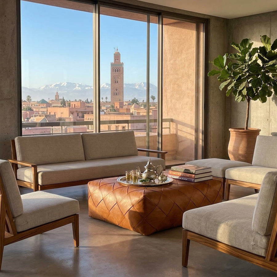 Square leather pouf serving as a table for a Moroccan tea tray in a sunlit room facing the Atlas mountains