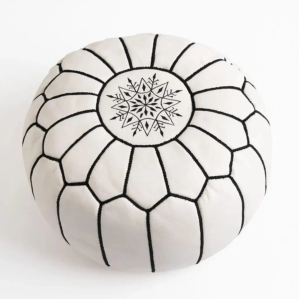White Moroccan leather pouf, 21 inch round ottoman with hand-embroidered black geometric star medallion, on a plain studio background
